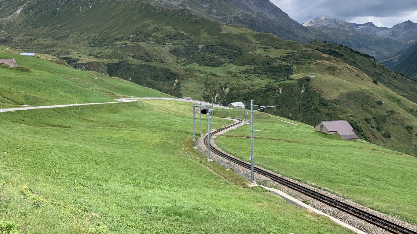 Spot auf die über Wiesenmatten führende Bahnstrecke am Oberalp